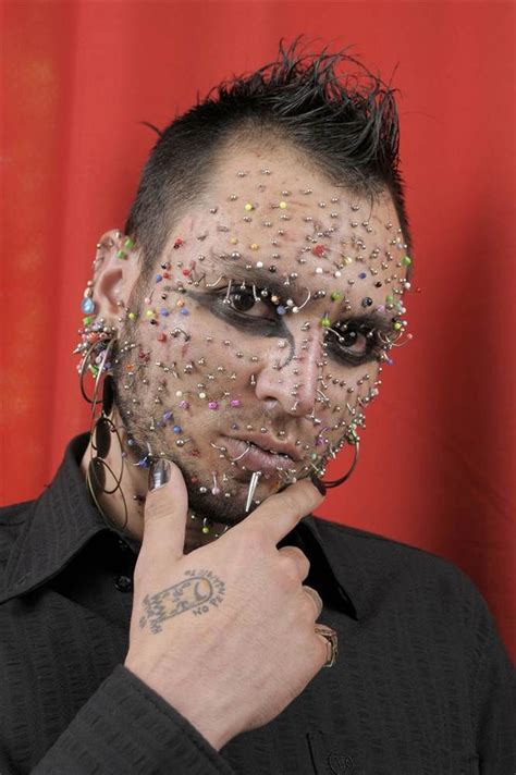 piercings all over face.